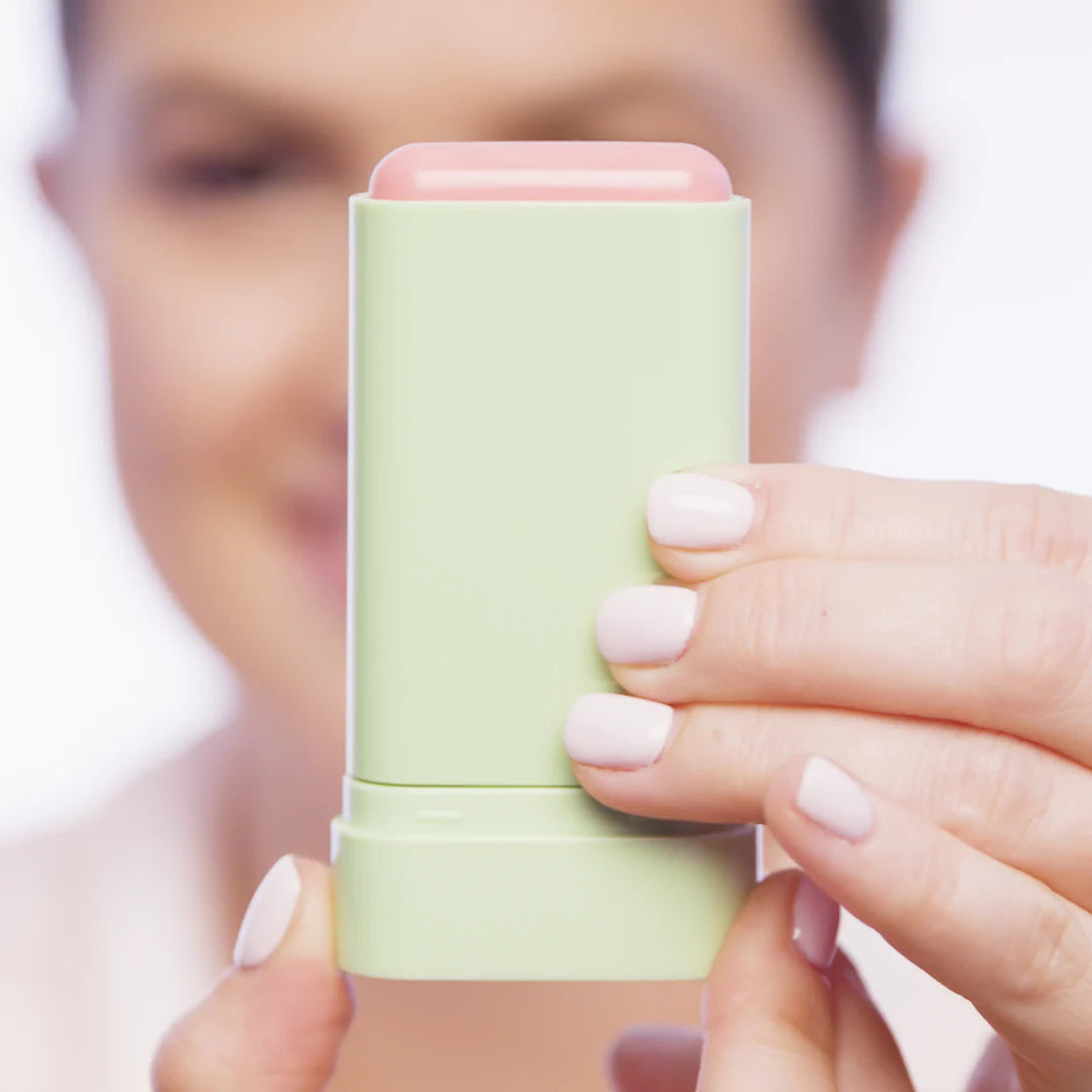 Pixi On-the-Glow Blush Stick model applying Fleur shade on cheeks dewy finish